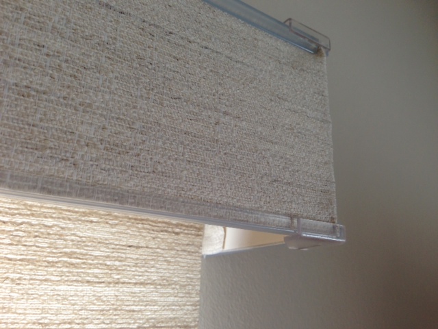 valance showing plastic clips.  These are expensive custom shades used in living areas not a kitchen or laundry room.