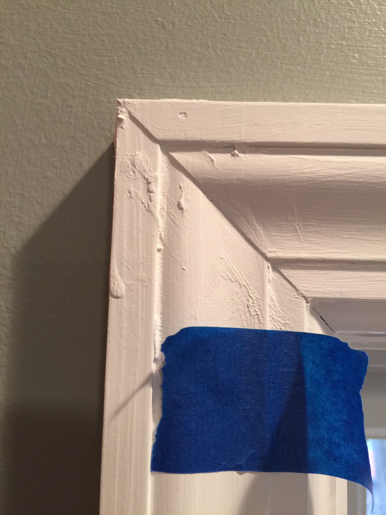 Brand new molding covered in caulk and excess paint. Must be sanded and repainted. Unfortunately, ALL of the molding looks like this.