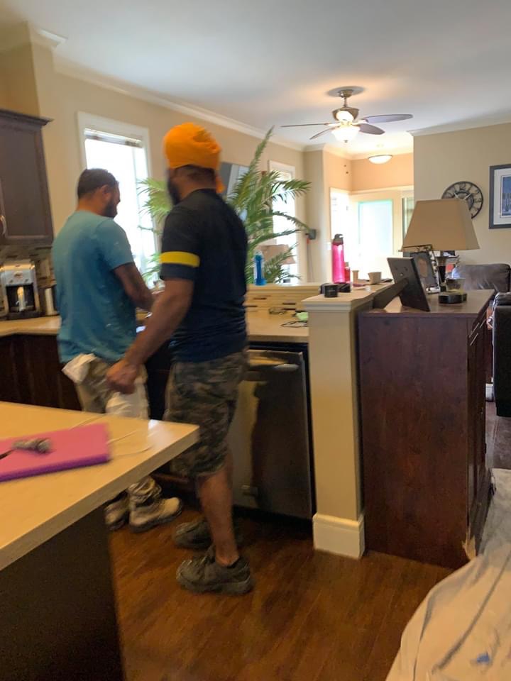 Crew inside his home pouring a glass of water. 