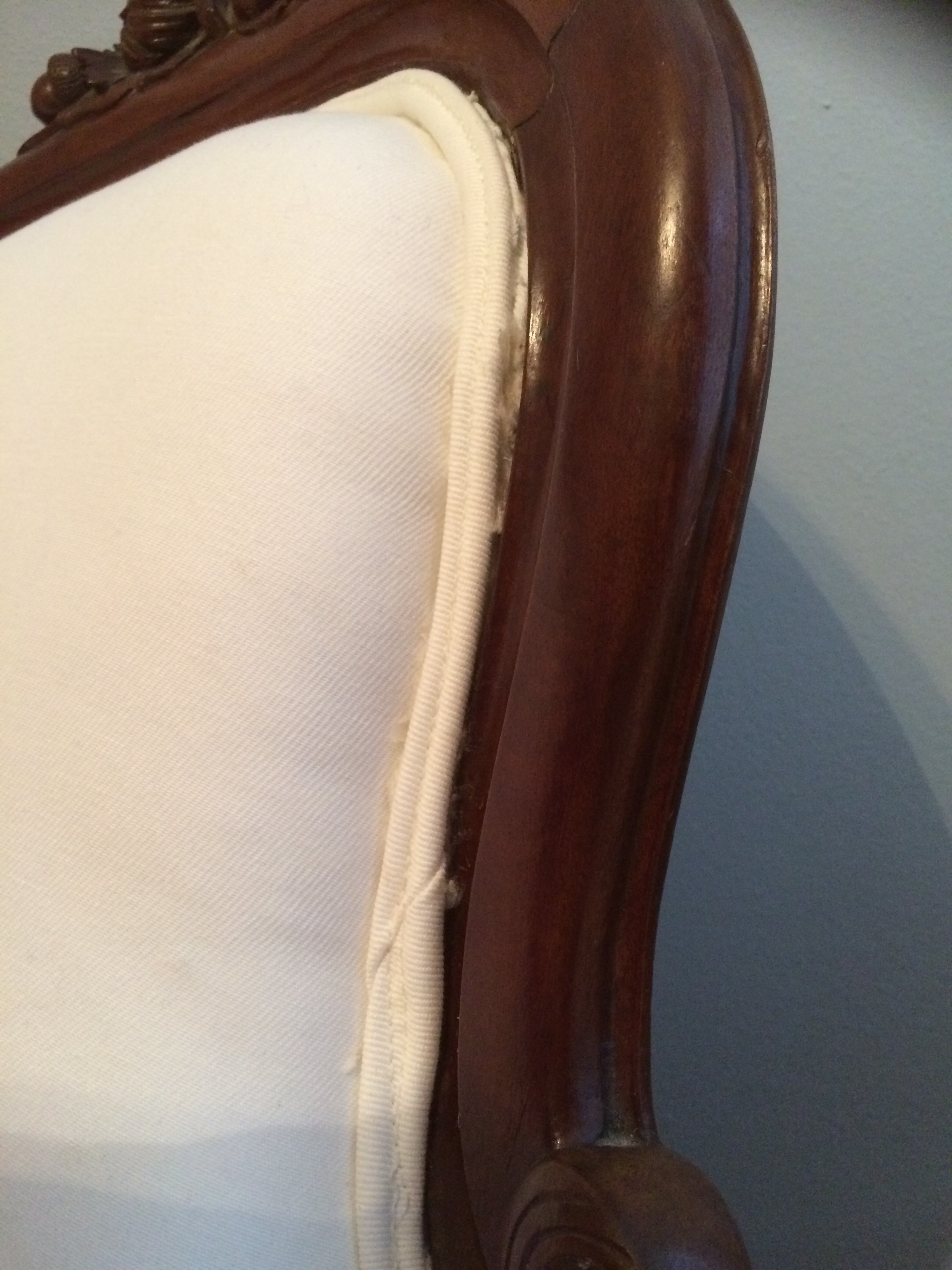 Visible globs of glue; visible fraying edge of upholstery not covered by welting. 