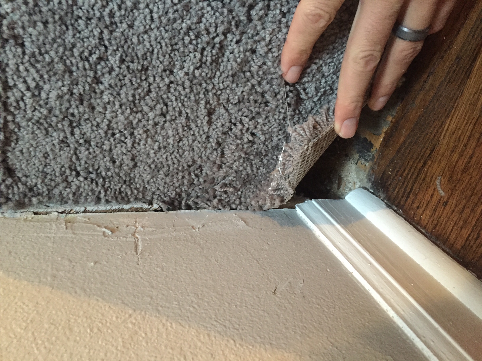 Carpet never secured properly thus allowing cold air in from the garage below.