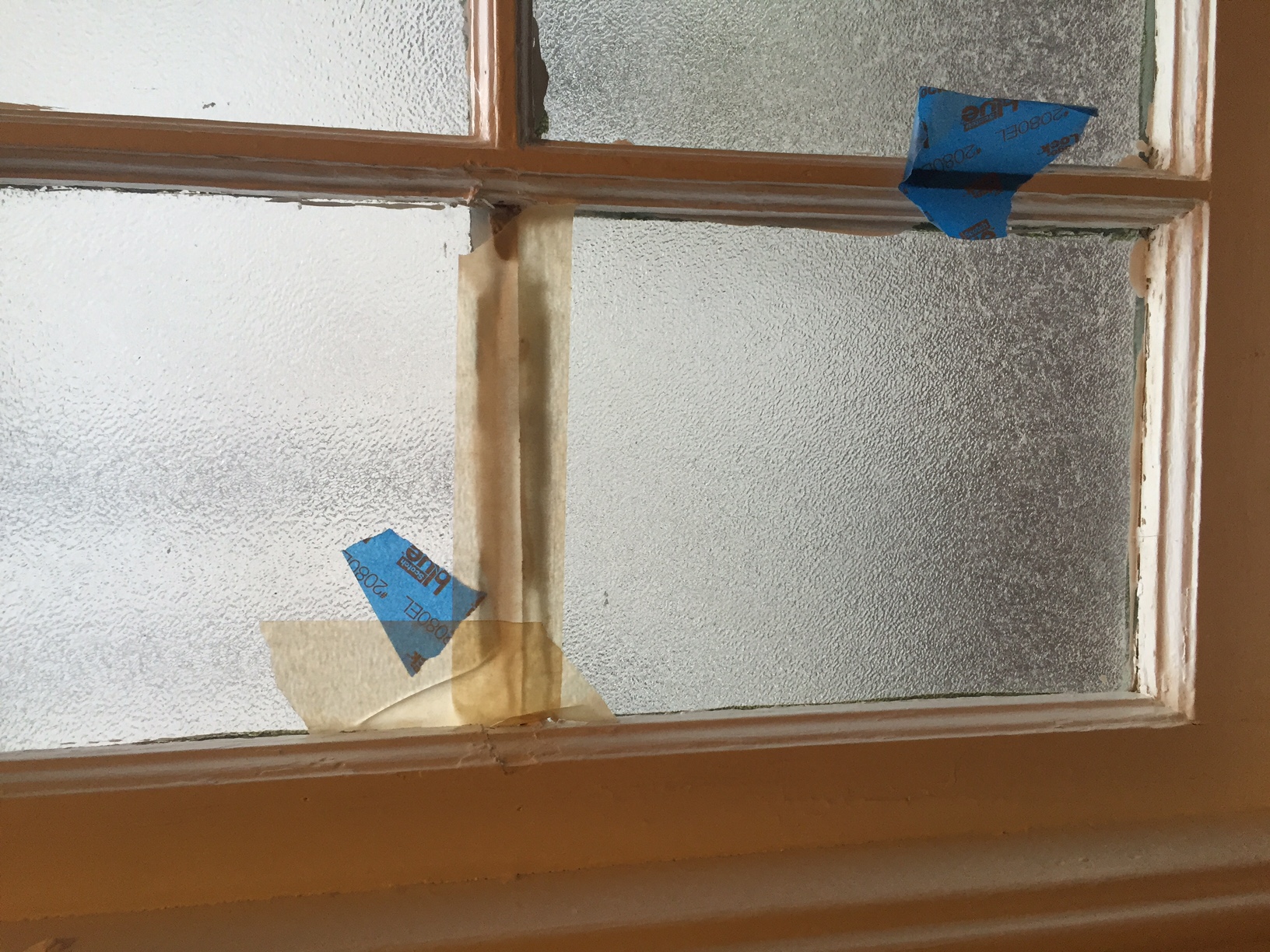 Broken window left with nothing but tape on it to keep the air and elements out of the house.