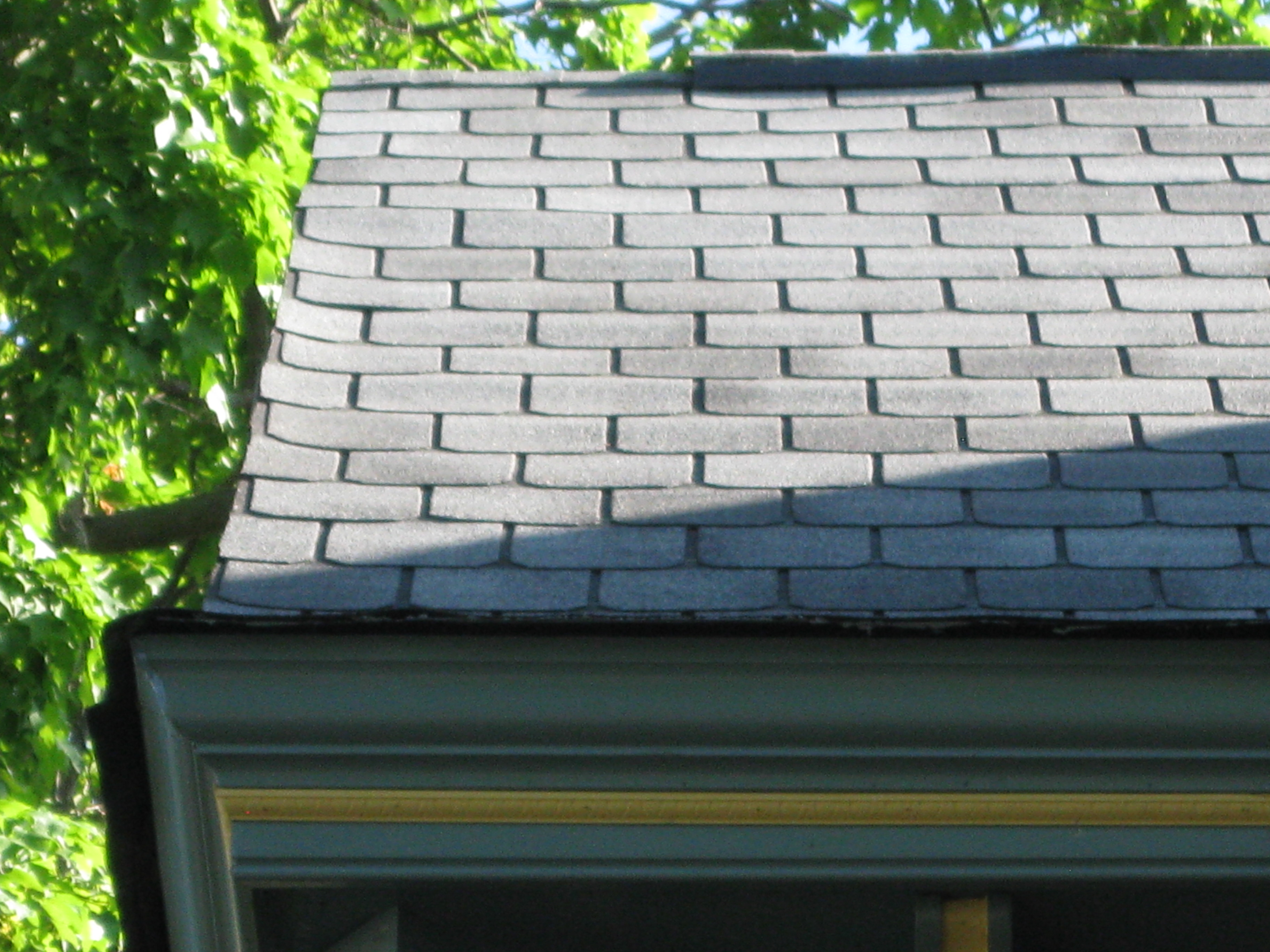 Look at the seams between shingles wondering to the right and left as you look up the roof. See the shingles that curl up at the left edge. See the inconsistent shingle tabs size on the left edge. Is 