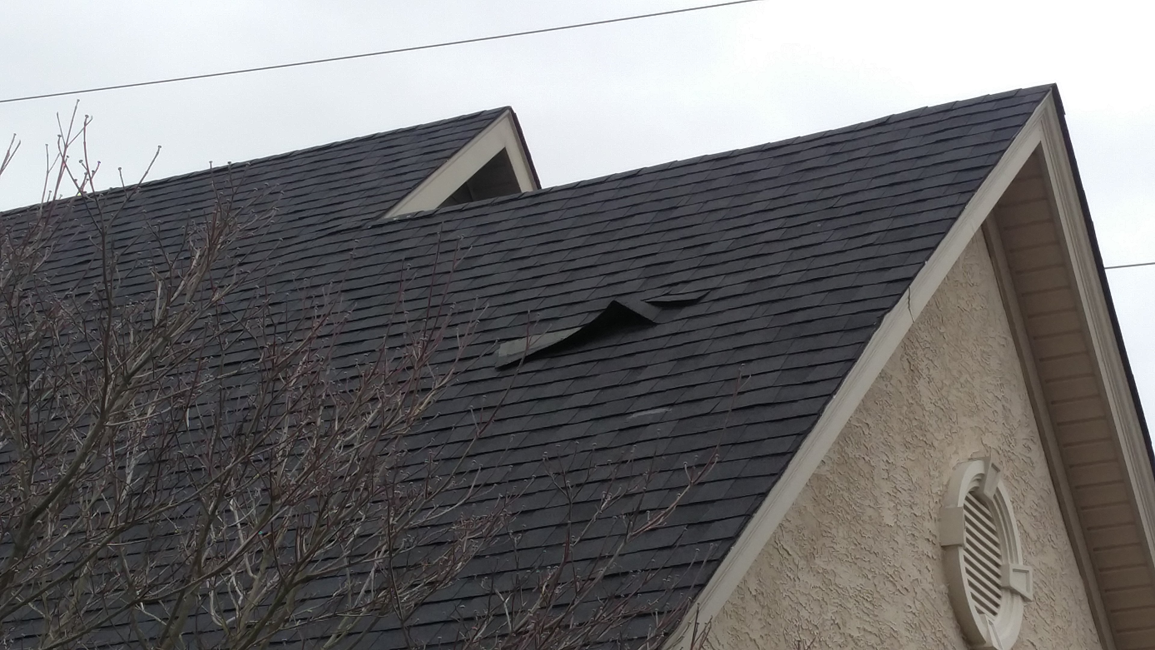 Bottom view of roof shingles falling off. It's only one month old and they are all very loose.