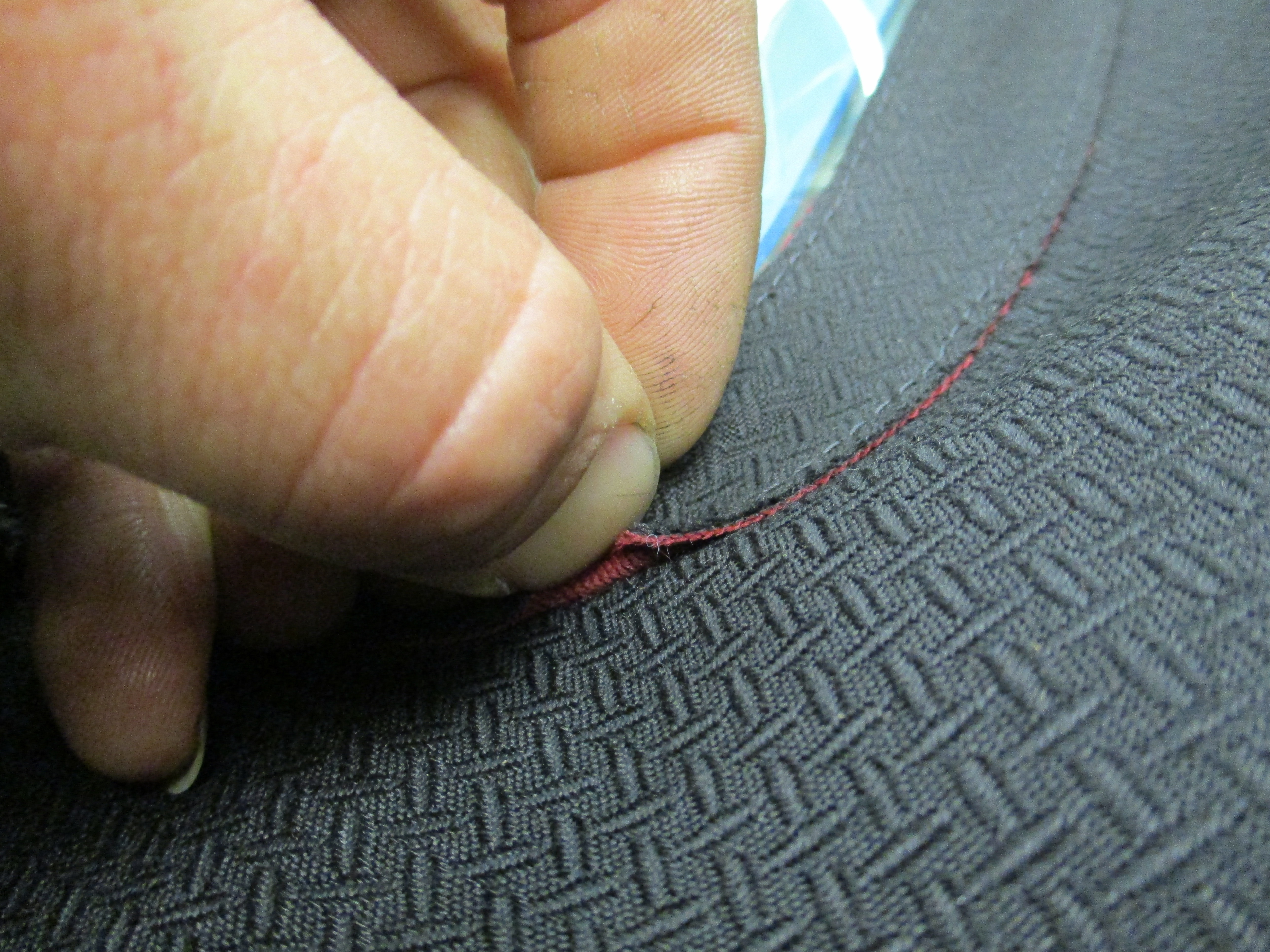 Non matching material used to bind endge of plastic window. The top is black cloth, the binding layer is red. This is visible from the outside of the car in the form of a read line around the perimete